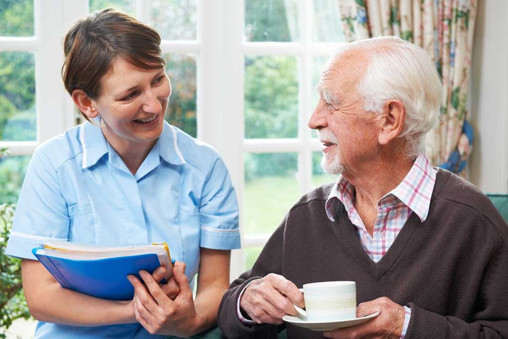 Family members review care documents with an older adult at an assisted living table.
