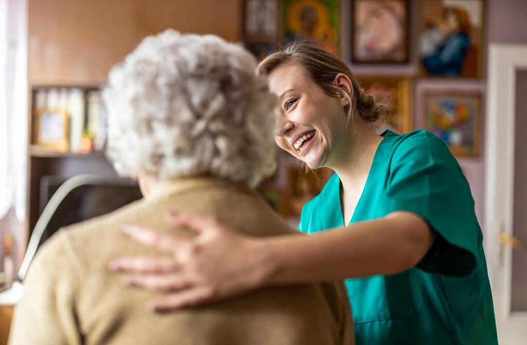 Staff guide older residents through a bright assisted living hallway during an emergency preparedness drill.