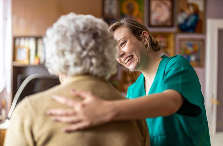 Staff guide older residents through a bright assisted living hallway during an emergency preparedness drill.